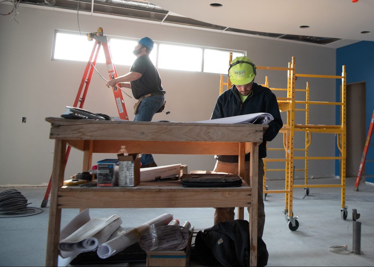 superintendent reading blueprints on a job site